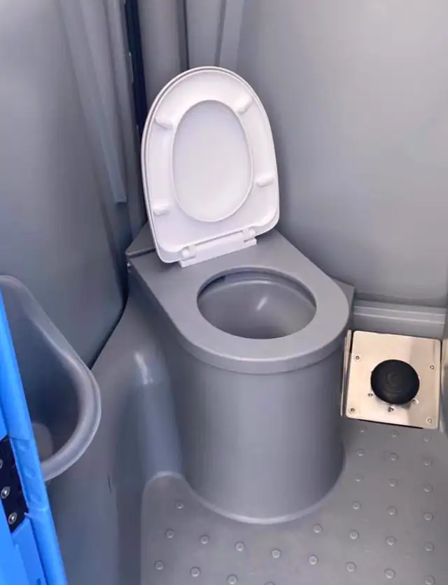 Deluxe portable toilet interior with a flushing bowl and lid