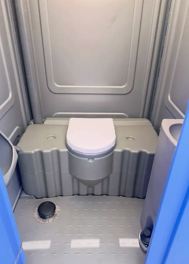 Freshly serviced porta potty interior with clean seat and floor