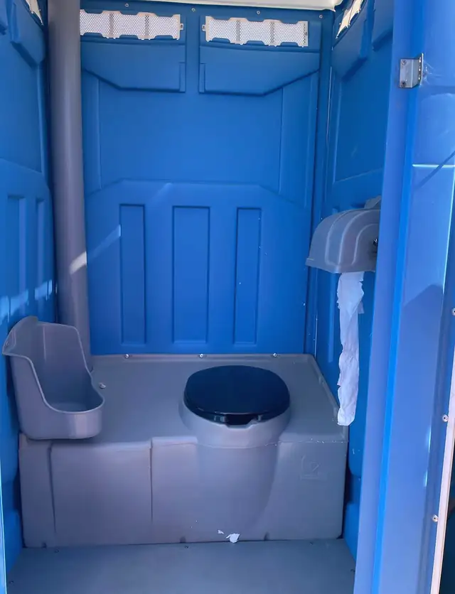 Standard porta potty interior with urinal, seat and toilet paper
