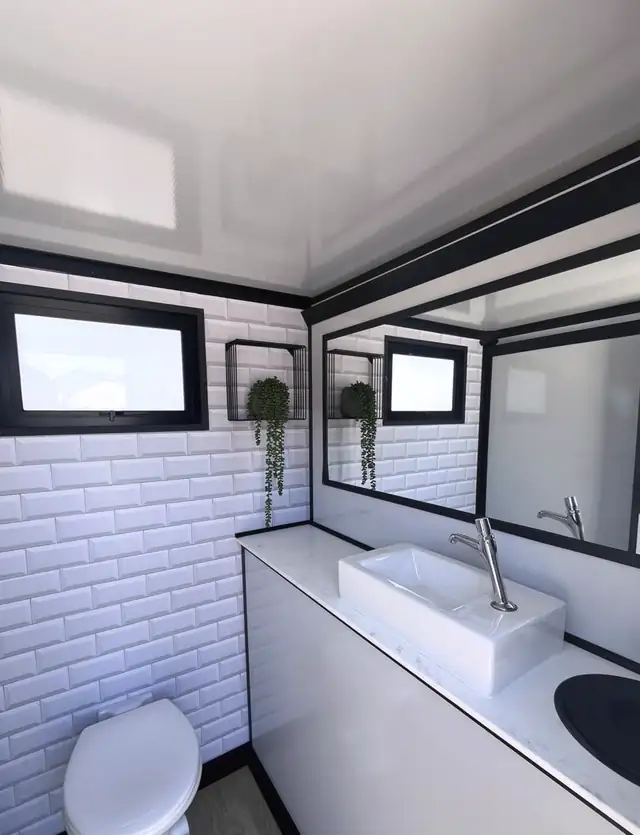 Restroom trailer interior with subway tile, sink and mirror