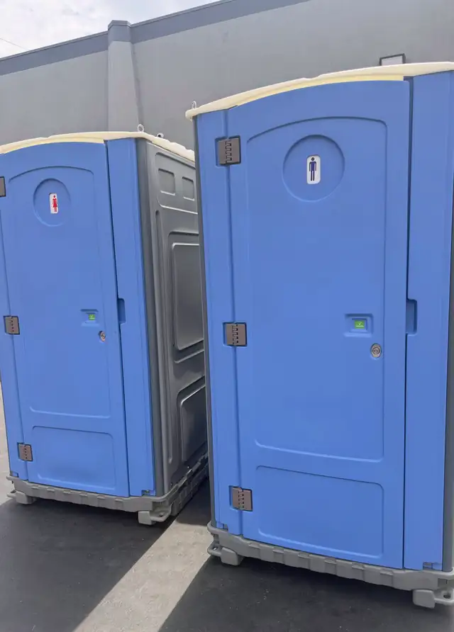 Two blue standard porta potties ready for delivery